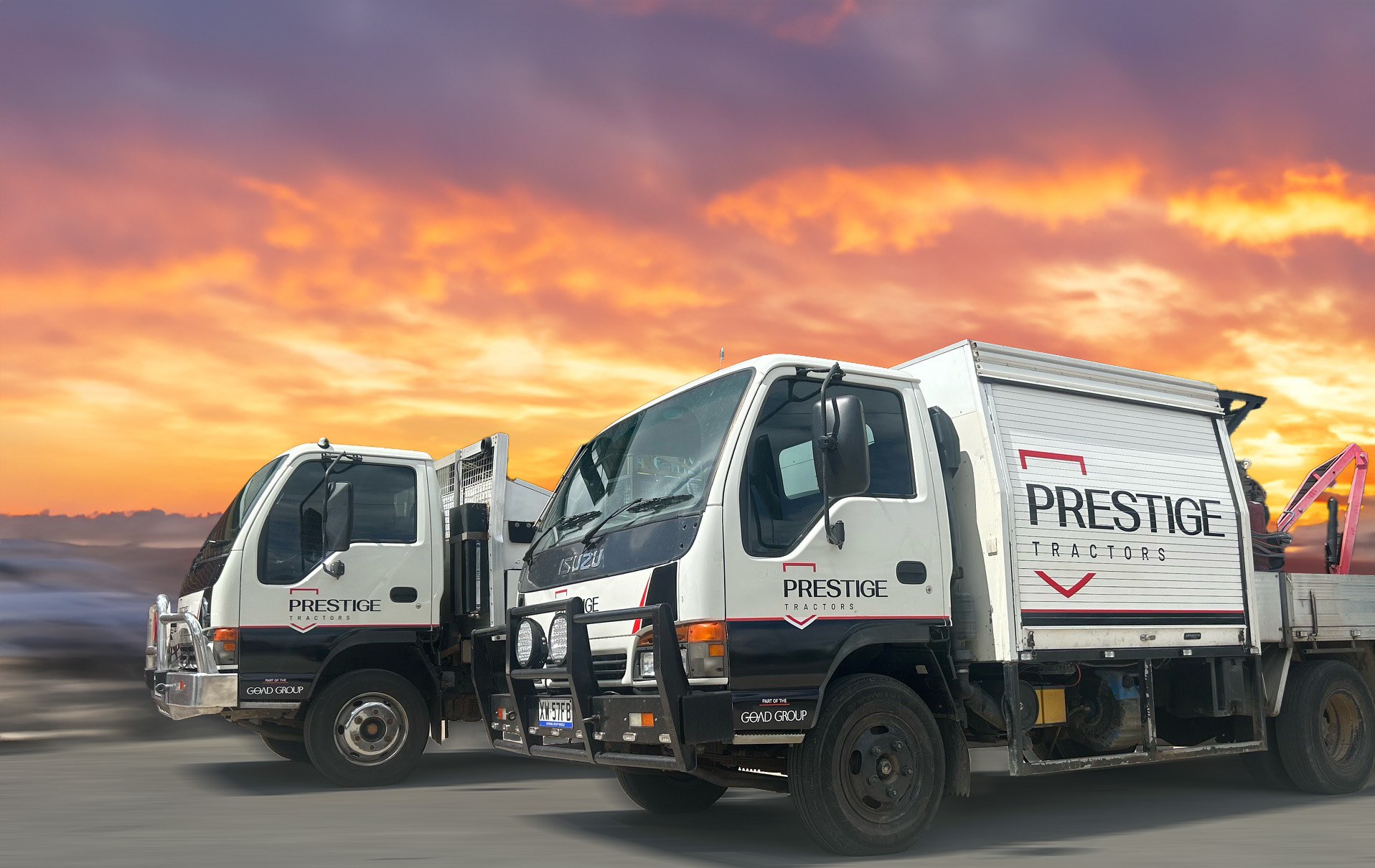 Two white Prestige Fleet Maintence trucks parked next to each other. The background is an orange to purplr sunset